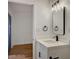 Modern bathroom featuring a white vanity, sleek black faucet, and a stylish framed mirror with unique lighting at 8412 Mulcahy Ave, Las Vegas, NV 89145