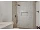 Modern bathroom featuring a large shower with marble-style tiling, a built-in niche, and a rainfall shower head at 8412 Mulcahy Ave, Las Vegas, NV 89145