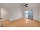 Well-lit bedroom showcasing wood floors, a modern ceiling fan, and sliding glass door access to the yard at 8412 Mulcahy Ave, Las Vegas, NV 89145
