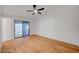 Spacious bedroom showcasing wood flooring, a modern ceiling fan, and a glass sliding door for natural light at 8412 Mulcahy Ave, Las Vegas, NV 89145