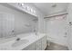 Well-lit bathroom featuring double sinks, vanity, large mirror, and tiled floor at 8529 Gold Flash Ave, Las Vegas, NV 89129