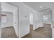 A hallway with white walls and brown carpet leading to other rooms in the house at 8529 Gold Flash Ave, Las Vegas, NV 89129