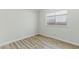 Secondary bedroom with window, wood-look floors, and white walls at 9116 Cypress Point Way, Las Vegas, NV 89117