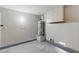 Tidy garage featuring an updated water heater, epoxy flooring, and clean gray walls at 9116 Cypress Point Way, Las Vegas, NV 89117
