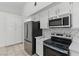 Bright kitchen with marble countertops, tile backsplash, stainless steel appliances, and white cabinetry at 9116 Cypress Point Way, Las Vegas, NV 89117