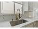 Close up of kitchen sink with gold fixtures, marble countertops, and white cabinetry at 9116 Cypress Point Way, Las Vegas, NV 89117