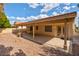 Covered patio extending to a low-maintenance backyard with gravel and mature trees at 9116 Cypress Point Way, Las Vegas, NV 89117