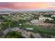 An elevated view of a sprawling community with manicured golf courses and luxurious homes against a beautiful horizon at 912 Pro Players Dr, Las Vegas, NV 89134
