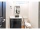 Stylish powder room with modern sink, black vanity, and unique block window offers functional elegance at 912 Pro Players Dr, Las Vegas, NV 89134