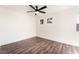 Minimalist bedroom with light-colored walls, dark wood floors, and a modern ceiling fan at 912 Pro Players Dr, Las Vegas, NV 89134