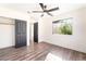 Bright bedroom features wood floors, neutral walls, a ceiling fan, and a view to the backyard at 912 Pro Players Dr, Las Vegas, NV 89134