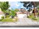 Charming house with a two-car garage, mature trees, green grass, and a concrete driveway at 912 Pro Players Dr, Las Vegas, NV 89134