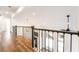 Second floor hallway with hardwood floors and black railings overlooking the home's entry and main floor at 912 Pro Players Dr, Las Vegas, NV 89134