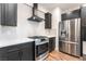 Modern kitchen featuring stainless steel appliances, dark cabinetry, and a stylish range hood at 912 Pro Players Dr, Las Vegas, NV 89134