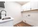Functional laundry room featuring white cabinetry, a sink, and space for a washer and dryer at 912 Pro Players Dr, Las Vegas, NV 89134
