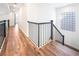 Upstairs landing with hardwood floors, glass block window, and elegant black metal railing at 912 Pro Players Dr, Las Vegas, NV 89134