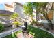 Landscaped backyard with water fountain and lush greenery including trees and artificial turf at 912 Pro Players Dr, Las Vegas, NV 89134