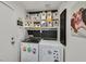 Laundry room featuring modern washer and dryer units, ample storage shelves, and whimsical cartoon decor at 9151 Indian Breeze Dr, Las Vegas, NV 89129