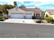 Charming single-story stucco home with a three-car garage and lush desert landscaping at 9728 Echo Hills Dr, Las Vegas, NV 89134
