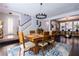 Bright dining area with stylish chandelier, wood table, and a view of the staircase and entry at 10526 Harvest Wind Dr, Las Vegas, NV 89135