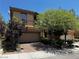 Charming two-story home featuring mature trees, a brick driveway, and an attached two-car garage at 10526 Harvest Wind Dr, Las Vegas, NV 89135