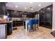 Kitchen with dark wood cabinets, stainless steel appliances, tile backsplash and granite countertops at 10526 Harvest Wind Dr, Las Vegas, NV 89135