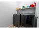 A practical laundry room with modern appliances and ample shelving for storage and laundry accessories at 10526 Harvest Wind Dr, Las Vegas, NV 89135