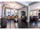 Open-concept living room with dark wood floors, stylish furnishings, and modern lighting at 10526 Harvest Wind Dr, Las Vegas, NV 89135