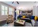 Inviting living room with a comfortable sofa, large windows, and a view of the modern kitchen at 10526 Harvest Wind Dr, Las Vegas, NV 89135