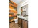 Stylish bathroom featuring unique colorful wood accent wall, granite countertops, and modern fixtures at 10987 Santorini Dr, Las Vegas, NV 89141