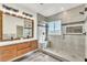 Bathroom with a modern double sink vanity, large mirror and a glass shower with a bench seat at 10987 Santorini Dr, Las Vegas, NV 89141