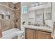 Bathroom with a vanity with granite counters, bathtub with tile surround, and shower head at 10987 Santorini Dr, Las Vegas, NV 89141