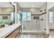 Bathroom featuring double vanity with modern lighting, glass shower, and mountain views from the window at 10987 Santorini Dr, Las Vegas, NV 89141
