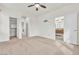 Spacious primary bedroom featuring neutral carpet, ceiling fan, and an ensuite bathroom and closet at 10987 Santorini Dr, Las Vegas, NV 89141