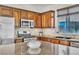 This kitchen features wood cabinets, stainless steel appliances, and a center island with granite countertop at 10987 Santorini Dr, Las Vegas, NV 89141