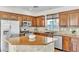 This kitchen features wood cabinets, stainless steel appliances, and a center island with granite countertop at 10987 Santorini Dr, Las Vegas, NV 89141