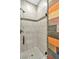 Shower with stylish tile, black trim and fixtures, next to an accent wall of unique colorful wood at 10987 Santorini Dr, Las Vegas, NV 89141