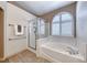 Bathroom showcases a soaking tub with a glass-enclosed shower and an arched window at 1126 Winter Storm Dr, Henderson, NV 89052