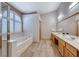 Bright bathroom showcases a large soaking tub, tiled floors, and a double vanity at 1126 Winter Storm Dr, Henderson, NV 89052