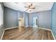 This bedroom has wood floors, a ceiling fan, an arched doorway, and natural light at 1126 Winter Storm Dr, Henderson, NV 89052