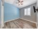 Bedroom with a ceiling fan, blue accent wall, modern window, and laminate flooring at 1126 Winter Storm Dr, Henderson, NV 89052