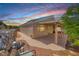 Charming single-story home with a covered patio and desert landscaping under a colorful sunset sky at 1126 Winter Storm Dr, Henderson, NV 89052