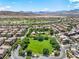 Scenic aerial view of a residential neighborhood with pool, community green space, and mountain views at 11375 Ogden Mills Dr # 103, Las Vegas, NV 89135
