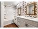 Updated bathroom features dual sinks, white cabinetry, and a tub-shower combination with subway tile surround at 11375 Ogden Mills Dr # 103, Las Vegas, NV 89135