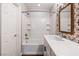 Bathroom with a tub-shower combination, white cabinetry and stylish wallpaper and accent mirrors at 11375 Ogden Mills Dr # 103, Las Vegas, NV 89135