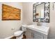 Stylish half bathroom features unique mirror and decorative wood accent at 11375 Ogden Mills Dr # 103, Las Vegas, NV 89135