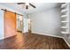 Bedroom with wood-look flooring, ceiling fan, built-in shelving and sliding barn door leading to the bathroom at 11375 Ogden Mills Dr # 103, Las Vegas, NV 89135