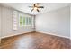 Spacious bedroom featuring wood-look floors, a ceiling fan, built-in shelving, and large window with shutters at 11375 Ogden Mills Dr # 103, Las Vegas, NV 89135