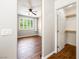 Bedroom with wood-look floors, ceiling fan, built-in shelving and a walk-in closet with an open door at 11375 Ogden Mills Dr # 103, Las Vegas, NV 89135