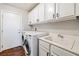 Laundry room with washer, dryer, white cabinetry and a utility sink at 11375 Ogden Mills Dr # 103, Las Vegas, NV 89135